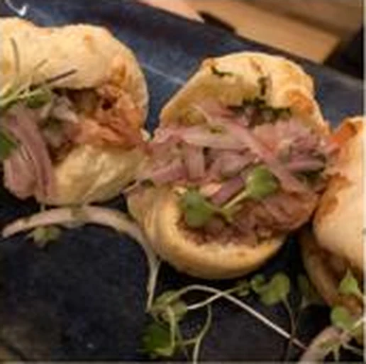Dos panes de yuca rellenos de cerdo cocinado a baja temperatura